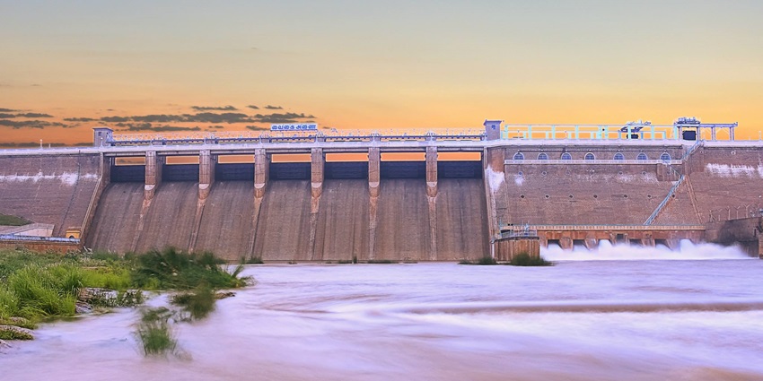 A scenic view of Vaigai Dam in Palani, with water and lush green surroundings.