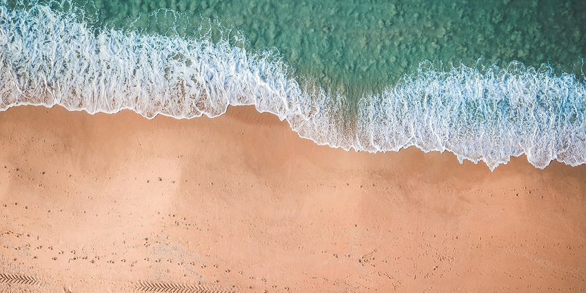A picturesque view of Vaitarna Beach with rolling waves and vibrant sunset colours.