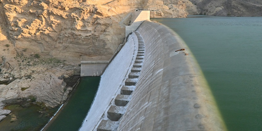 A panoramic view of the Vaitarna Dam in Igatpuri, with water flowing over the dam.