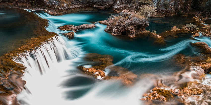 The breathtaking Vajrai Waterfalls cascading down rocks, surrounded by greenery and mist.