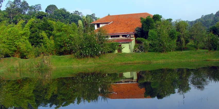 Picturesque view of a water body and a house  surrounded by greenery at Varlakonda.