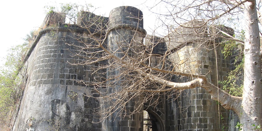 Main entrance to the ancient black and grey-coloured Vasai Fort for camping in Palghar.