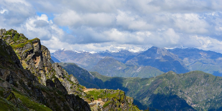 A picture of the north chain of mountains with a blue tank of sky and white clouds over yonder.