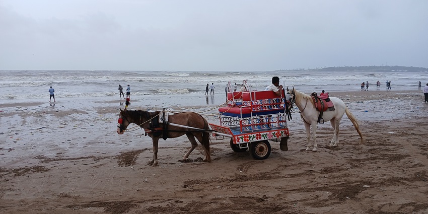Scenic view of Versova Beach with golden sands and gentle waves.