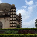 A picturesque garden view with Gol Gumbaz, one of the best things to do in Vijayapura.