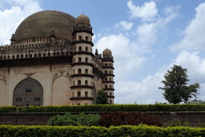 A picturesque garden view with Gol Gumbaz, one of the best things to do in Vijayapura.