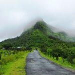 An image of Visapur Fort trekking showing rugged paths with lush greenery and scenic views