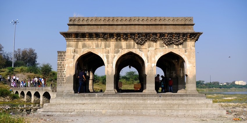 The Vishnupad temple in middle of the river has footsteps partially submerged in water.