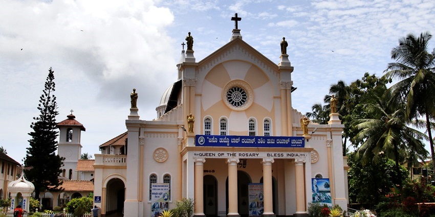 Glimpse of the historic Rosario Cathedral in Mangalore with arched windows and domed structure.