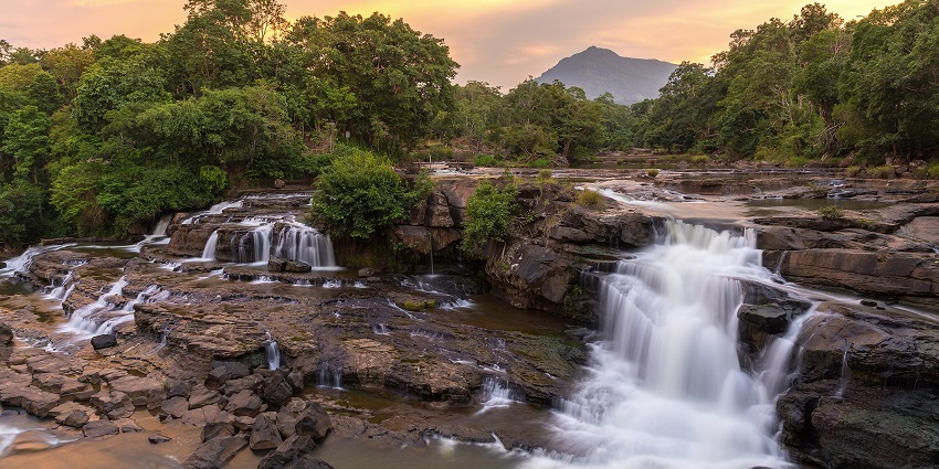 A scenic view of Chunchi Waterfalls in Karnataka, India, cascading over rocky cliffs amidst greenery.
