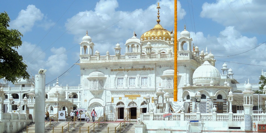 Hazur Sahib Gurudwara in Nanded, Maharashtra, featuring its white marble facade, golden domes, and surrounding greenery.