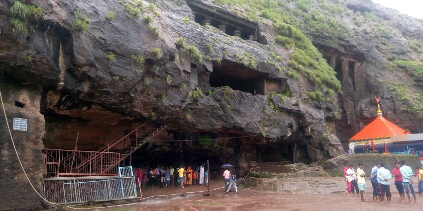 A picturesque view of Ekvira Aai Temple set against the backdrop of lush hills