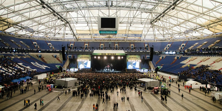 Wide angle view of the indoor stadium with a large crowd near the screen