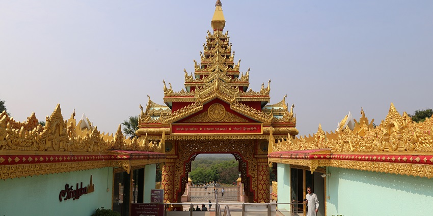 A picture of a Buddha temple with intricate carvings on the entrance wall
