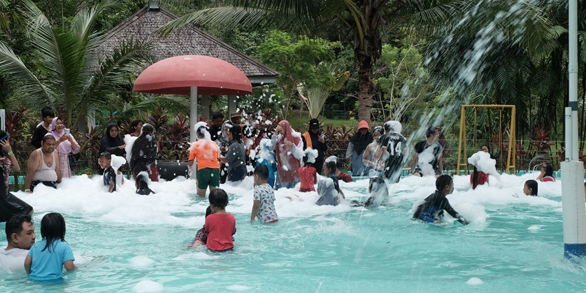 Group of people swimming in a pool in a water park near Ulhasnagar wearing a blue swimsuit