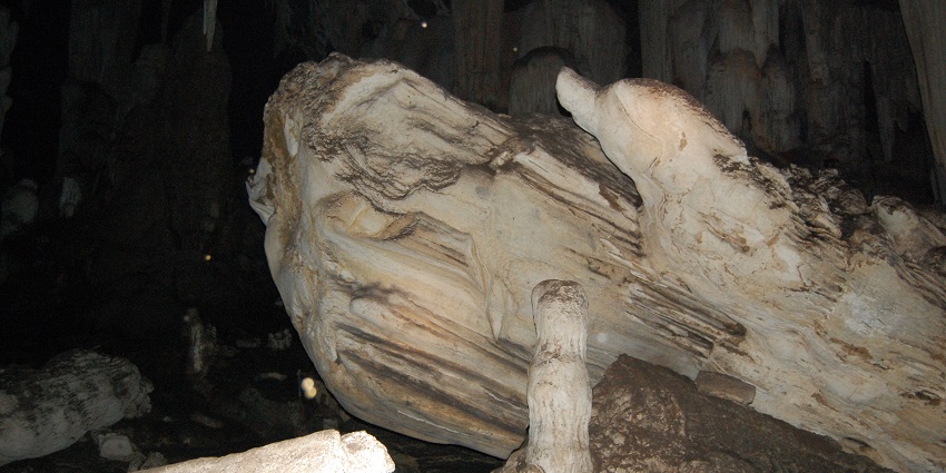 Rock-cut Wai cave entrance with stone pillars and weathered façade carved into a hillside.