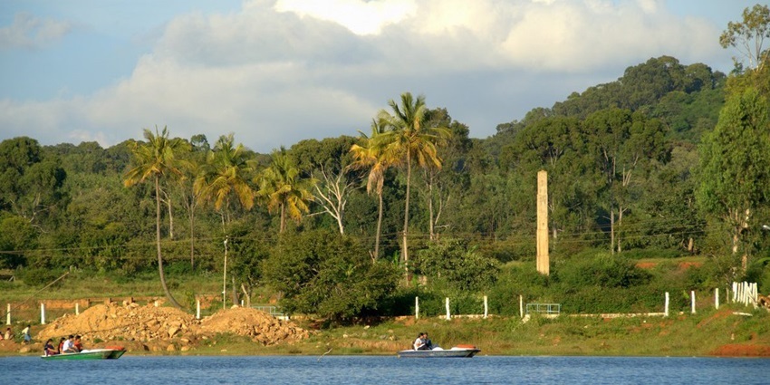 Yelagiri Lake Park surrounded by lush greenery and rolling hills under a clear blue sky.
