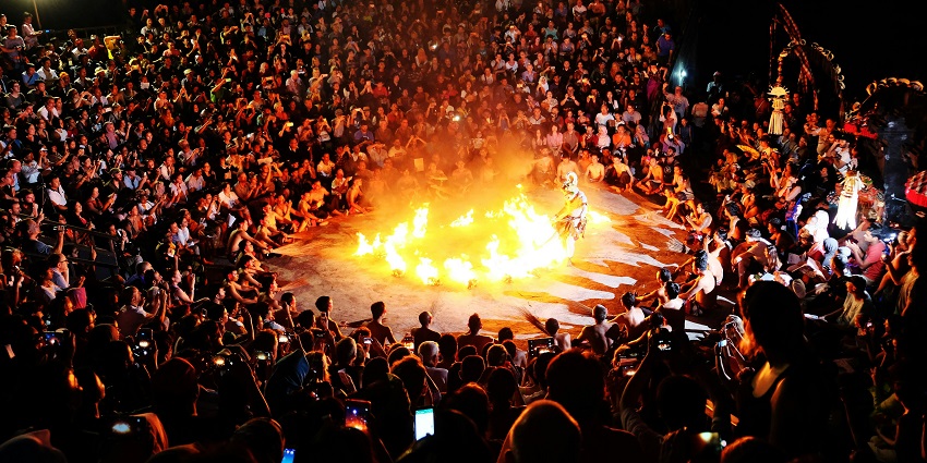 Vibrant Kecak fire dance performance in Bali, with flames illuminating the around dancers