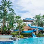 A view of the poolside area with numerous people sunbathing on loungers.