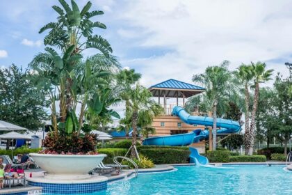 A view of the poolside area with numerous people sunbathing on loungers.