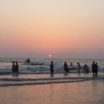 Sunset over Alibaug Beach, with vibrant colors reflecting on the calm water.