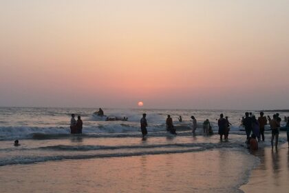 Sunset over Alibaug Beach, with vibrant colors reflecting on the calm water.