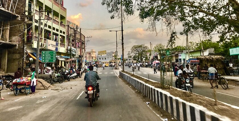 A wide road lined with trees in Amaravathi, India, showcasing greenery and a clear sky