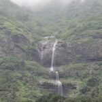 Scenic view of famous waterfalls in Maharashtra surrounded by abundant greenery and top hills.