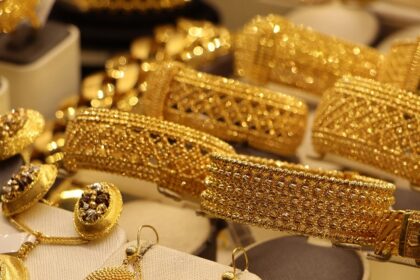 A glimpse of gold jewellery including bangles and necklaces presented at a store.