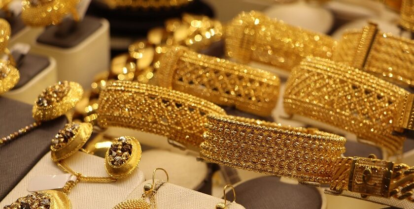 A glimpse of gold jewellery including bangles and necklaces presented at a store.