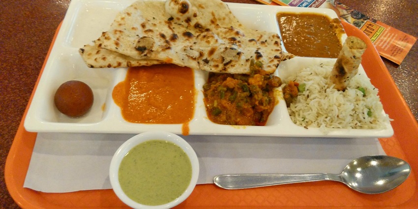 Image of North Indian Veg Thali with chutney and papad served on a white plate