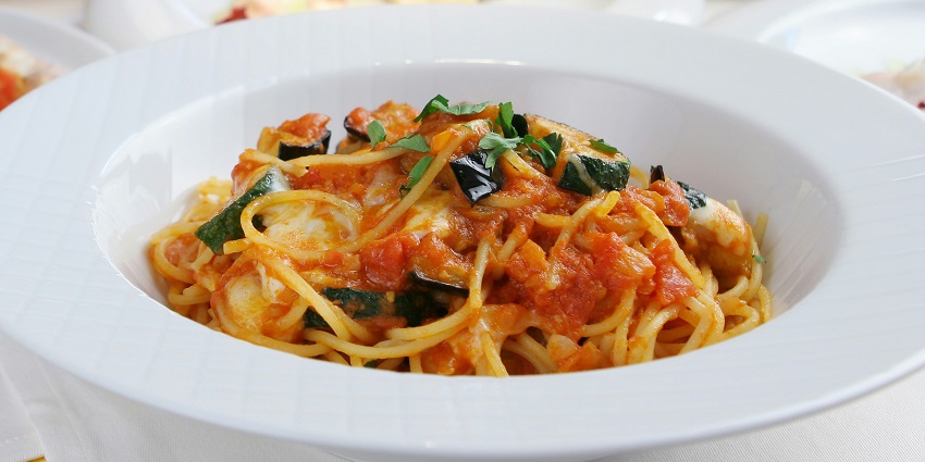 An image of a plate full of delicious pasta in a restaurant offering diverse cuisine.