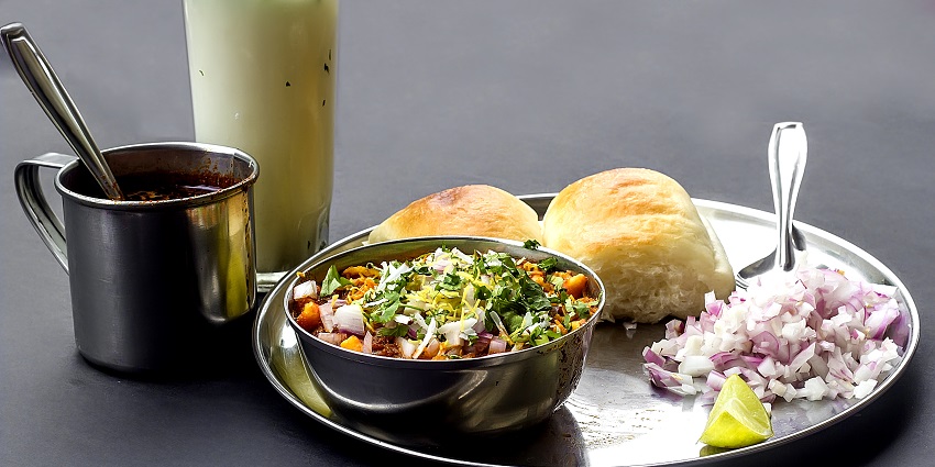 Plate of spicy Misal Pav served with garnishes, a popular Maharashtrian food.