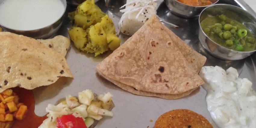 Maharashtrian thali featuring rice, vegetables, chapati, and delicious sweets
