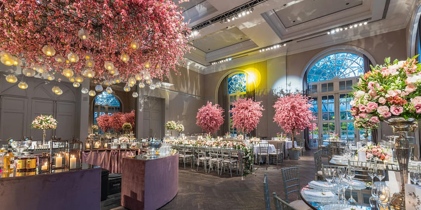 Stylish dining space featuring artificial cherry trees and floral arrangements for charm!