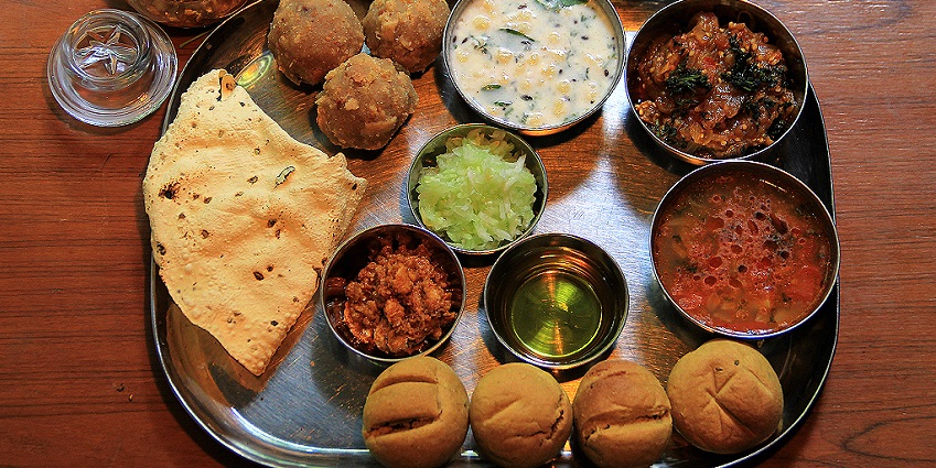 A thali of authentic Rajasthani food daal baati choorma with other accompaniment