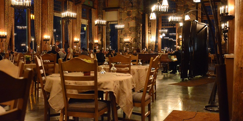 A beautifully arranged dinner table with plates, cutleries, and soft lighting