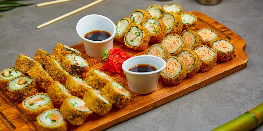 A top view of colorful sushi menu featuring various sushi rolls and fresh ingredients.