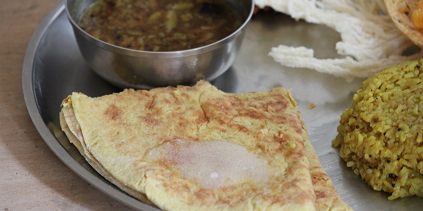 The image shows a traditional Maharashtrian dish with small portions of accompaniments