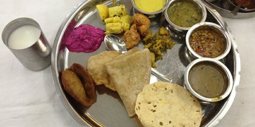 Maharashtrian thali with various dishes, including chapati, rice, vegetables, and curry.