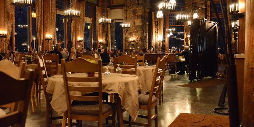 A beautifully arranged dinner table with plates, cutleries, and soft lighting