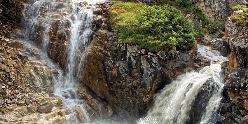 Picturesque view of Waghora Waterfall surrounded by rocky terrain and greenery showcasing flowing water.