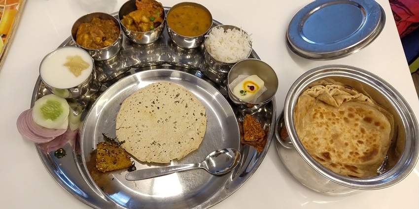 An array of traditional Indian dishes served in a thali in Madhya Pradesh, India.