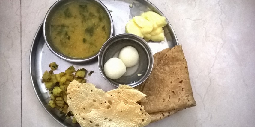 A traditional Maratha Thali at a famous restaurant near Manmodi caves with a variety of dishes.