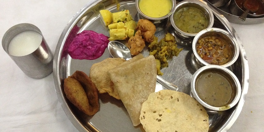 A Maharashtrian thali featuring a variety of traditional dishes served on a round plate.