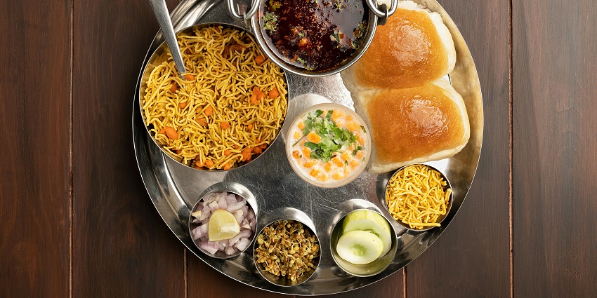 A Maharashtrian thali featuring a variety of traditional dishes, including rice, chapati