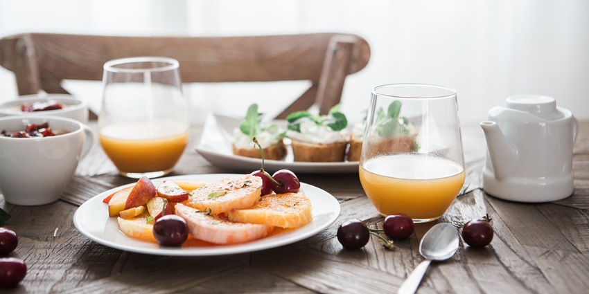 A refreshing drink with a delicious breakfast of fruits and pastries.