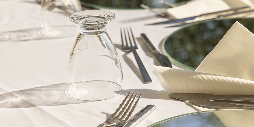 An elegantly set restaurant table with a beautifully arranged plate and cutlery.