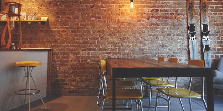 Cosy seating area with stylish chairs against a rustic brick wall backdrop