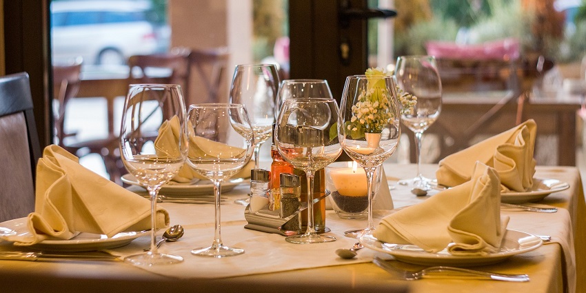 An elegant restaurant table setting with fine dishes, silverware, and decorative elements.